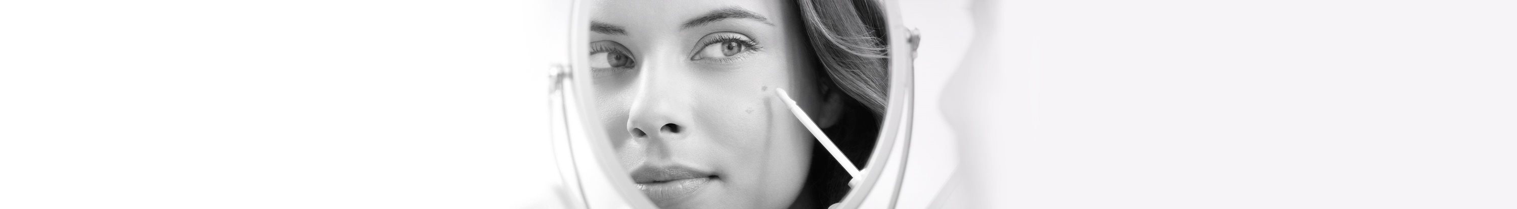 Woman applying Eucerin Even Brighter Spot Corrector while watching herself in the mirror