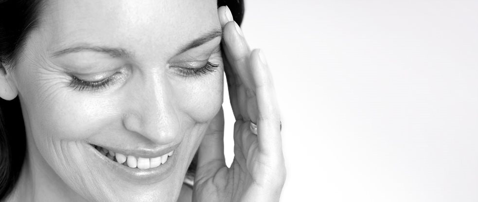 Woman touching her face with her left hand.
