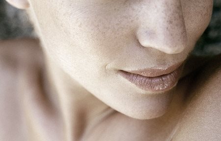 Lower part of a woman´s face with freckles.