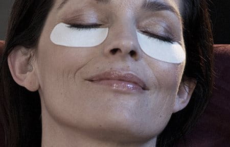 Woman´s face with care pads under her eyes.