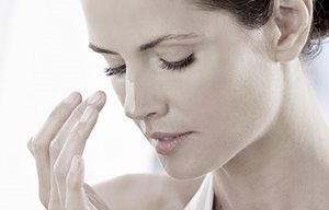 Woman applying sun screen her nose.