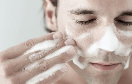 Woman applying cream on her face to hydrate skin
