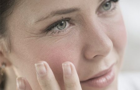 Woman touching her face with hand